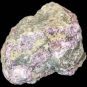 Colour image of gray rock mottled with with green, pink and yellow rock